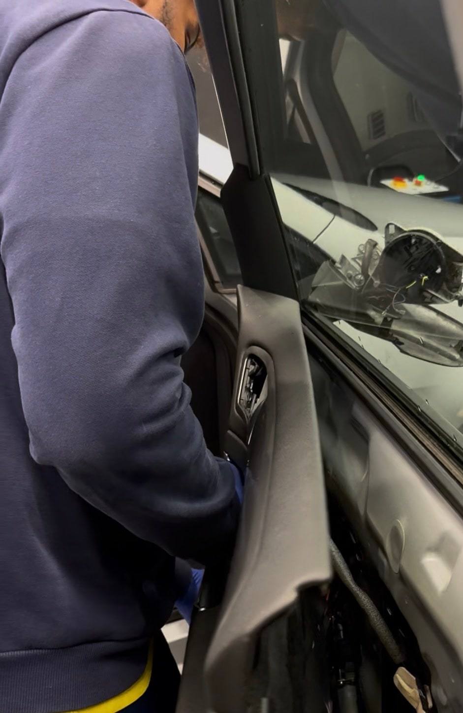 Een medewerker van Al Midra aan het werk aan de binnenkant van een autodeur
